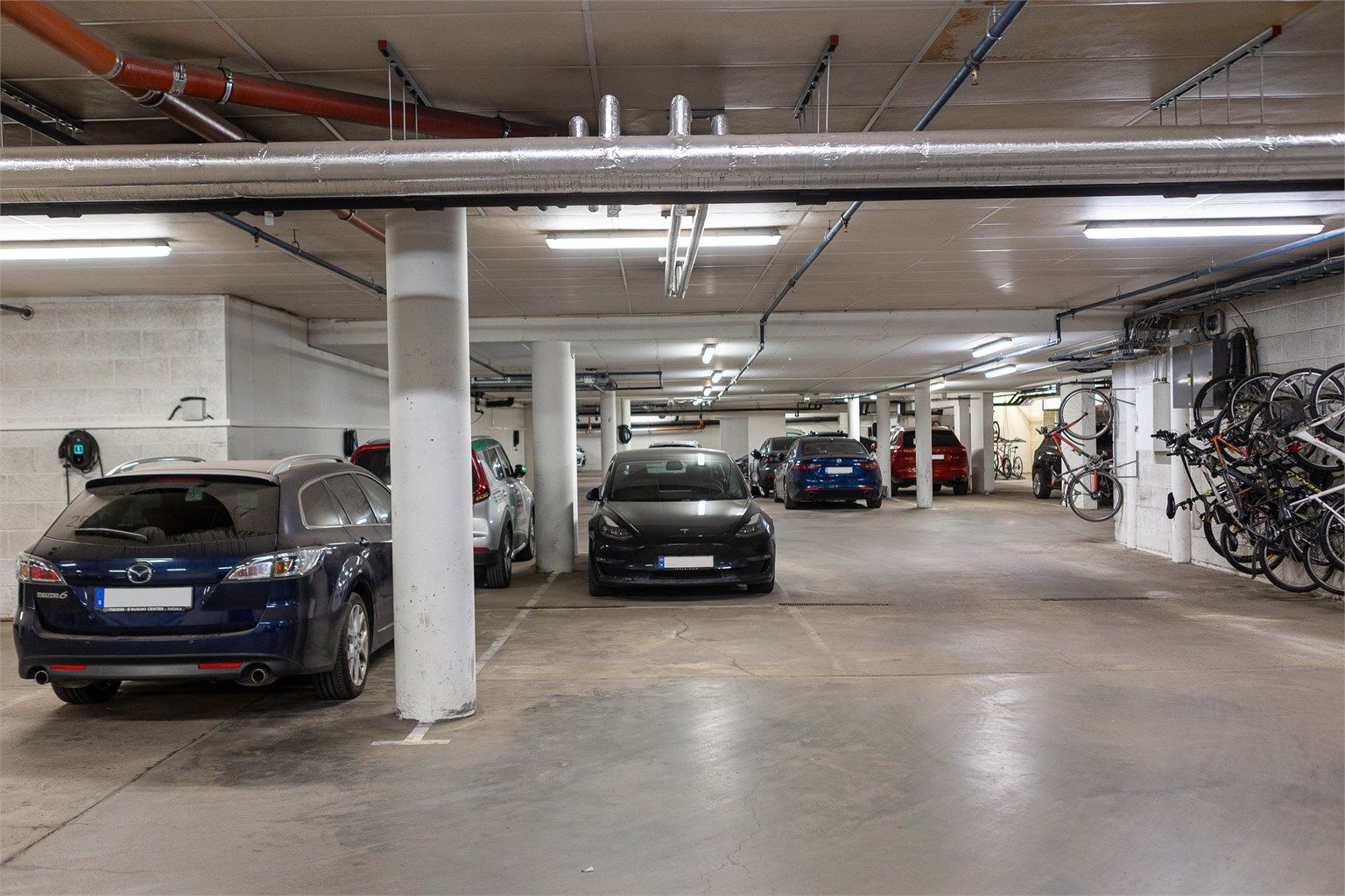 Med leiligheten følger en parkeringsplass i garasjeanlegg, klargjort for montering av elbillader. Adkomsten til boligen er svært praktisk, med inngangsdøren til bygget plassert i umiddelbar nærhet til parkeringsplassen.