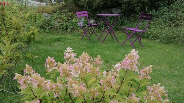 Den disponible hagen gir en fin forlengelse av boligen i sommerhalvåret, med rom for både sittegruppe og beplantning. (Selgers bilde)