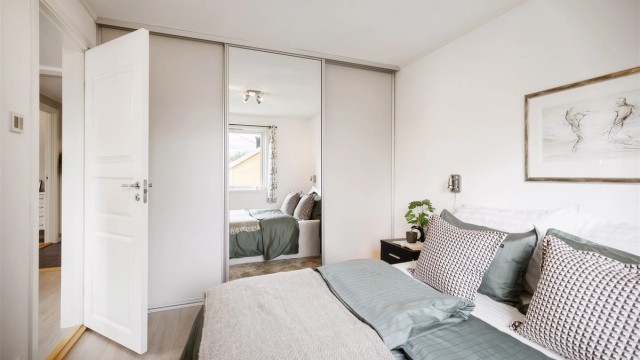 Stor skyvedørsgarderobe gir rikelig med oppbevaringsplass og bidrar til et ryddig og stilrent soverom.