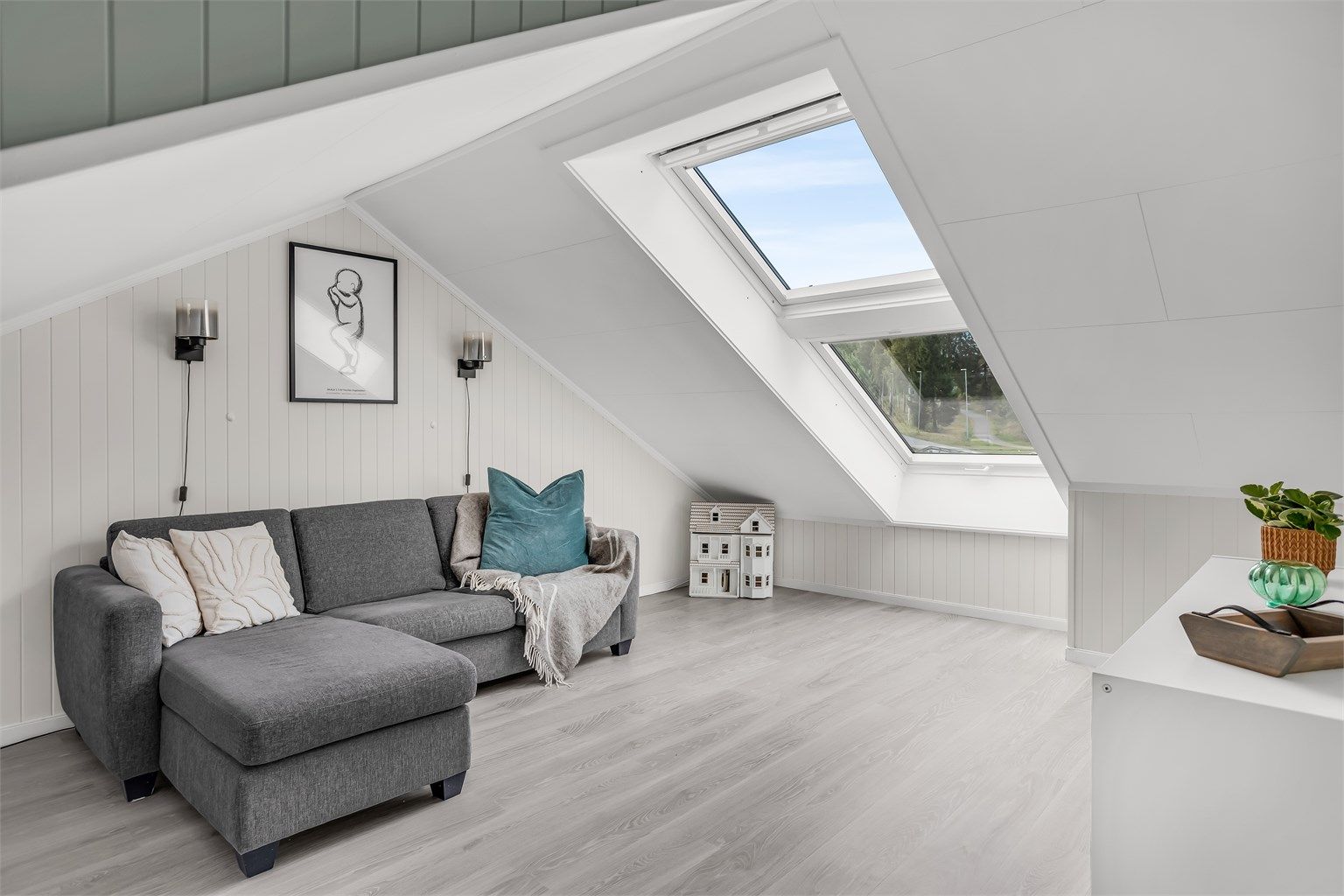 Lys og romslig loftstue med god plass til sittegruppe og øvrig møblering.