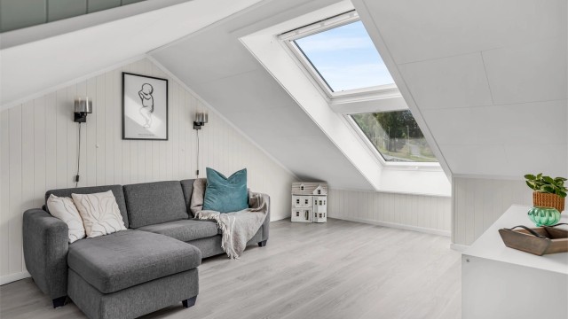 Lys og romslig loftstue med god plass til sittegruppe og øvrig møblering.