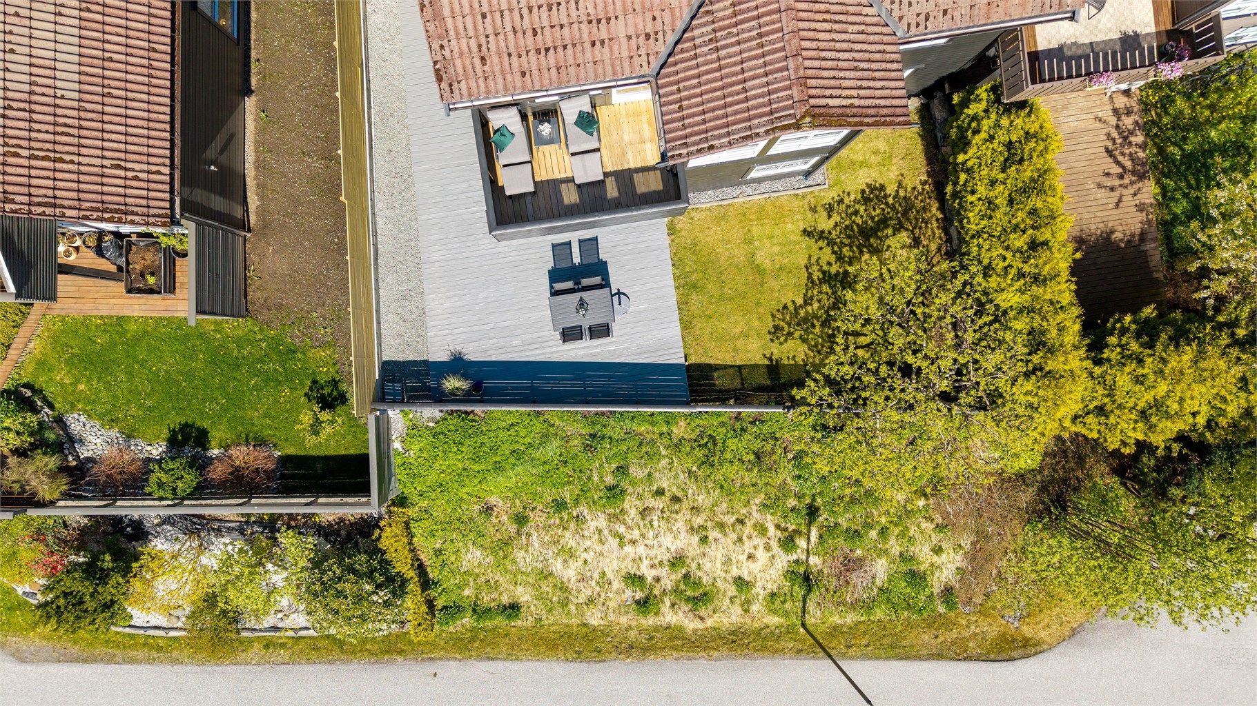 Tomten er svakt skrånende og pent opparbeidet over to nivåer.