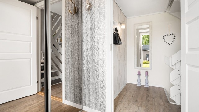 Entréen har plass til oppbevaring og leder videre inn i boligen.