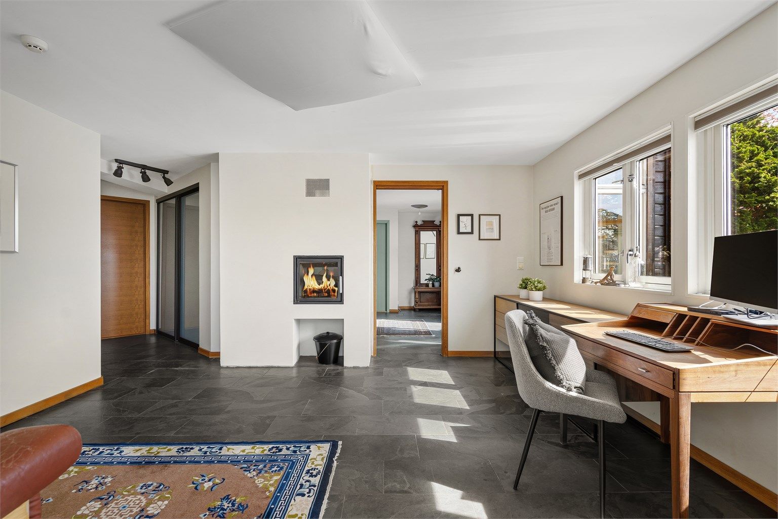 Mellom entré og hall har man fin peis. Fra hall kan man gå rett inn i vinterhage, som går over to plan. Herfra kan man gå direkte ut til solrik terrasse og uteplass .
