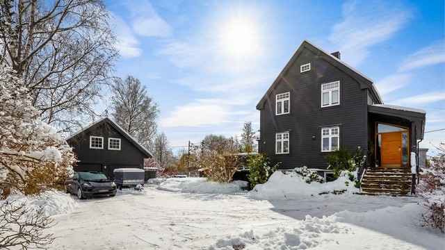 En betydelig påkostet enebolig med stor, separat garasjebygning.
