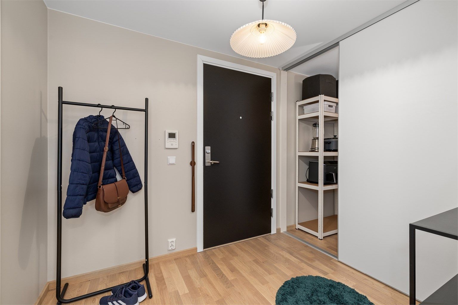 Innbydende og romslig entré med skyvedørsgarderobe for bedre orden og bedre oppbevaringsplass i hjemmet.
