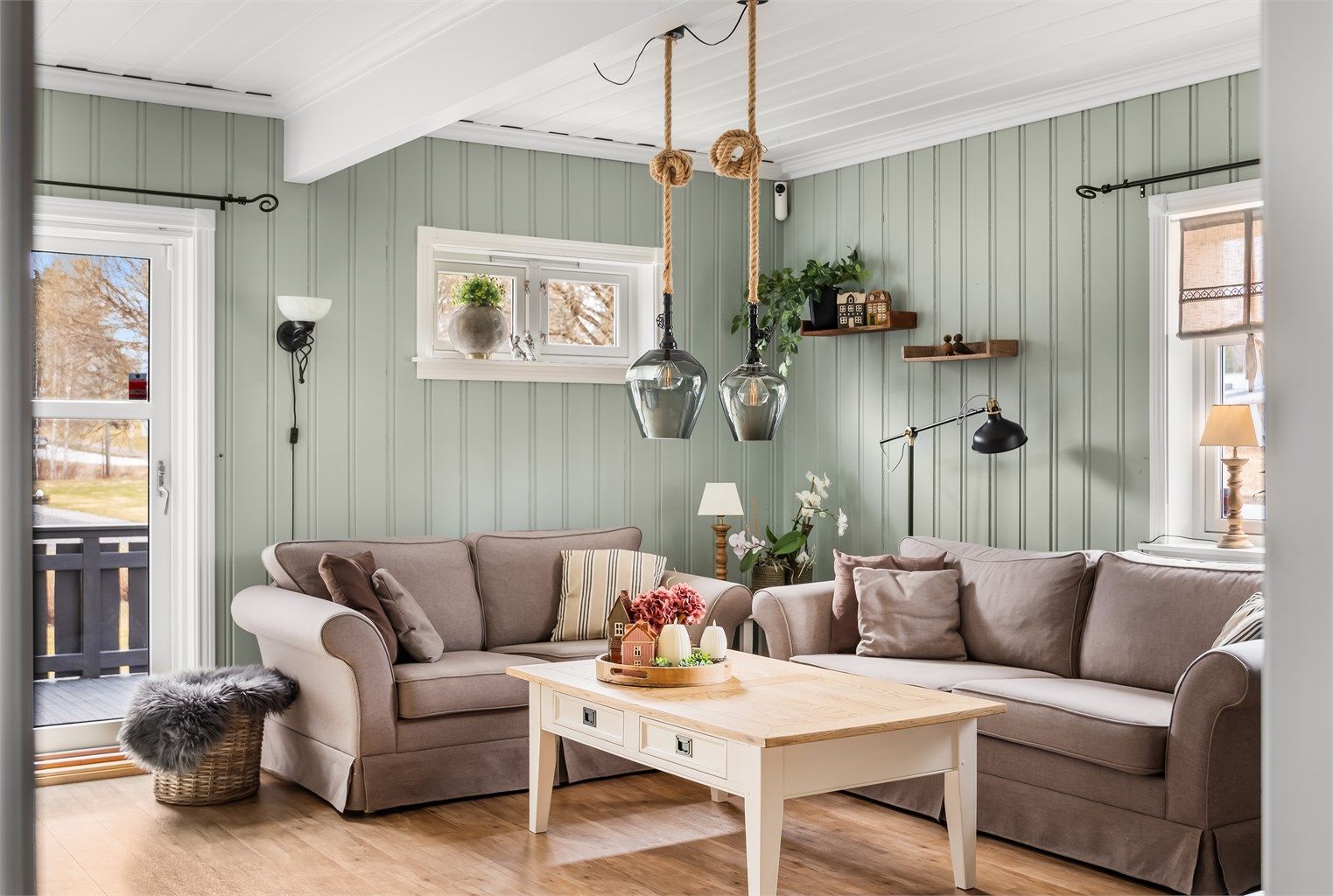 Hyggelig stue med lune fargetoner, god takhøyde og utgang til terrasse.