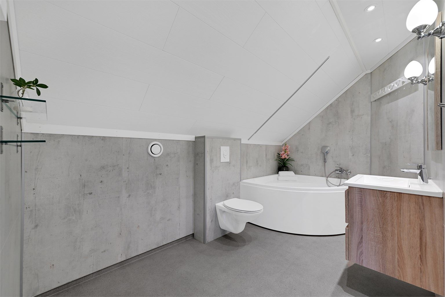 Badet er komplett med vegghengt toalett og en heldekkende servant med skuffeseksjon.