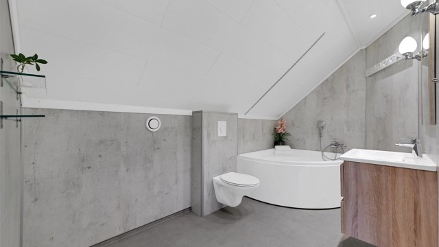 Badet er komplett med vegghengt toalett og en heldekkende servant med skuffeseksjon.
