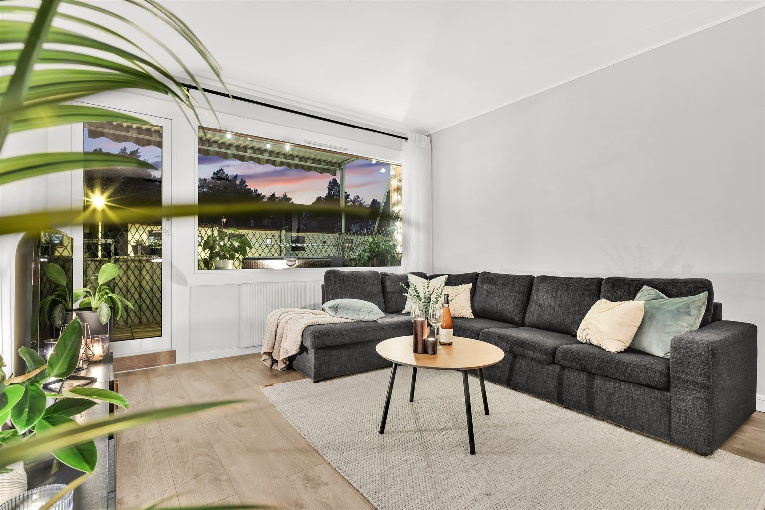 Koselig sofakrok ved de store vindusflatene.