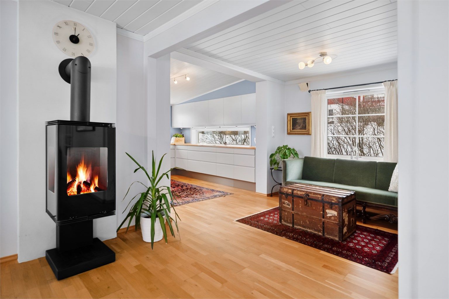 Stuen har en delvis åpen løsning mot kjøkkenet, som skaper en sosial og luftig romfølelse.