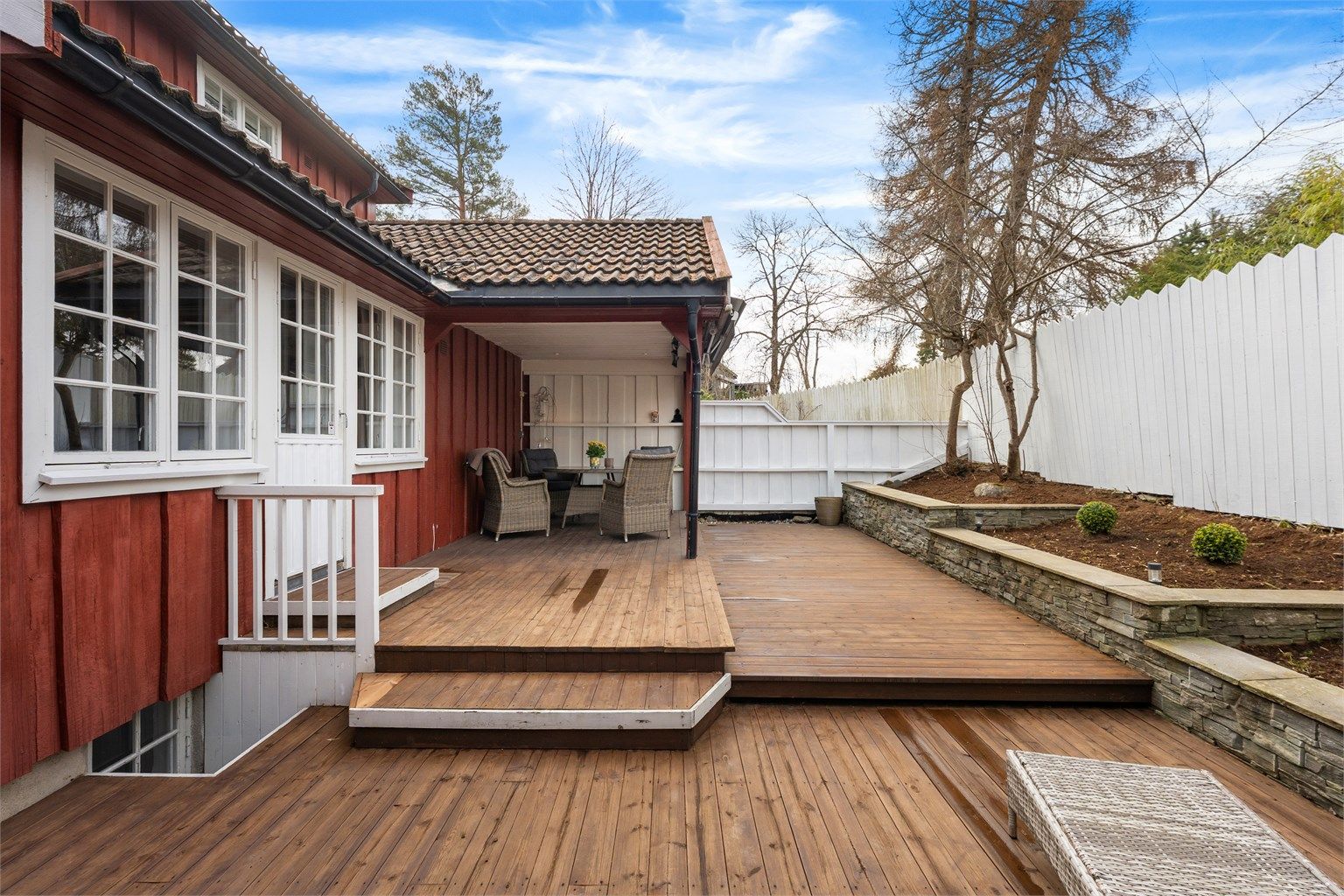 Uteområdet er pent opparbeidet med terrasse i tre og støttemur i naturstein.