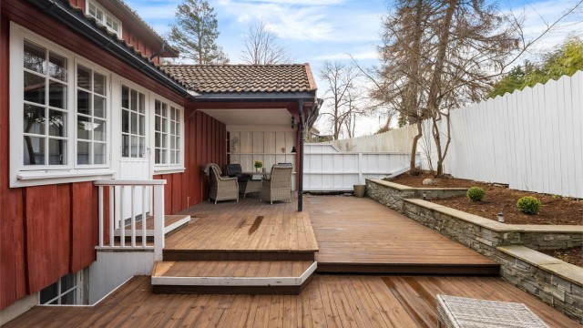 Uteområdet er pent opparbeidet med terrasse i tre og støttemur i naturstein.