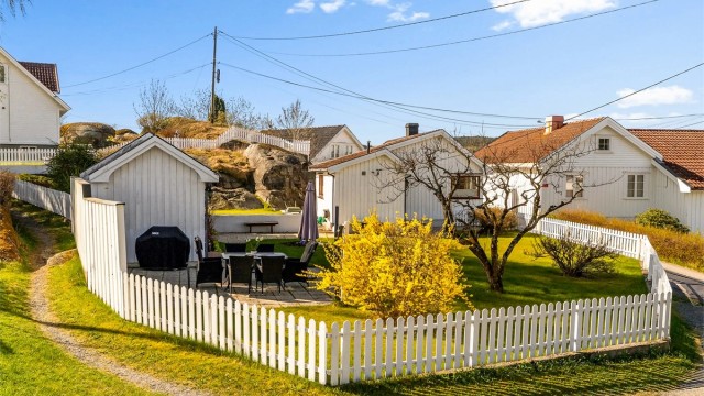 Hagen er inngjerdet og beplantet med fruktre, prydbusker og blomsterbed.
