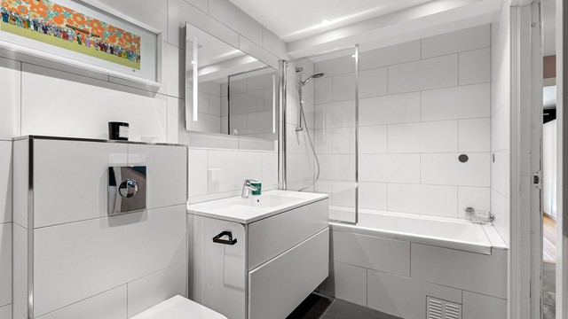 Innredningen er tidløs med hvite fliser og downlights i taket.