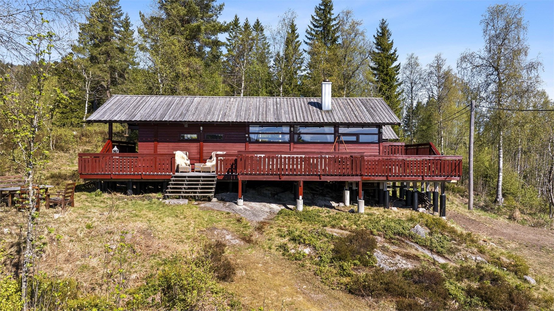 Hytta ligger på en stor og usjenert eiertomt på 2,3 mål. Den romslige terrassen på 92 m² omkranser hytta og gir rikelig med plass for uteliv. Foto: Maciej Krzysztof