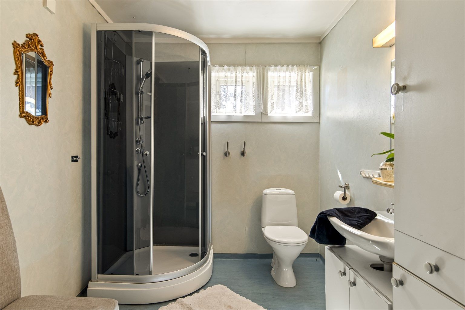 Badet er romslig og innredet med toalett, dusjkabinett, servant i innredning, nyere vvb og opplegg til vaskemaskin