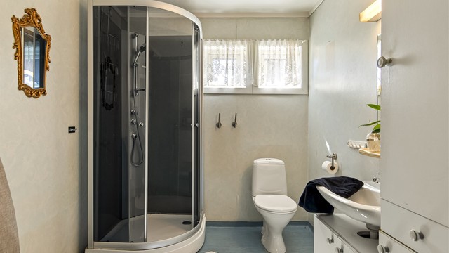 Badet er romslig og innredet med toalett, dusjkabinett, servant i innredning, nyere vvb og opplegg til vaskemaskin