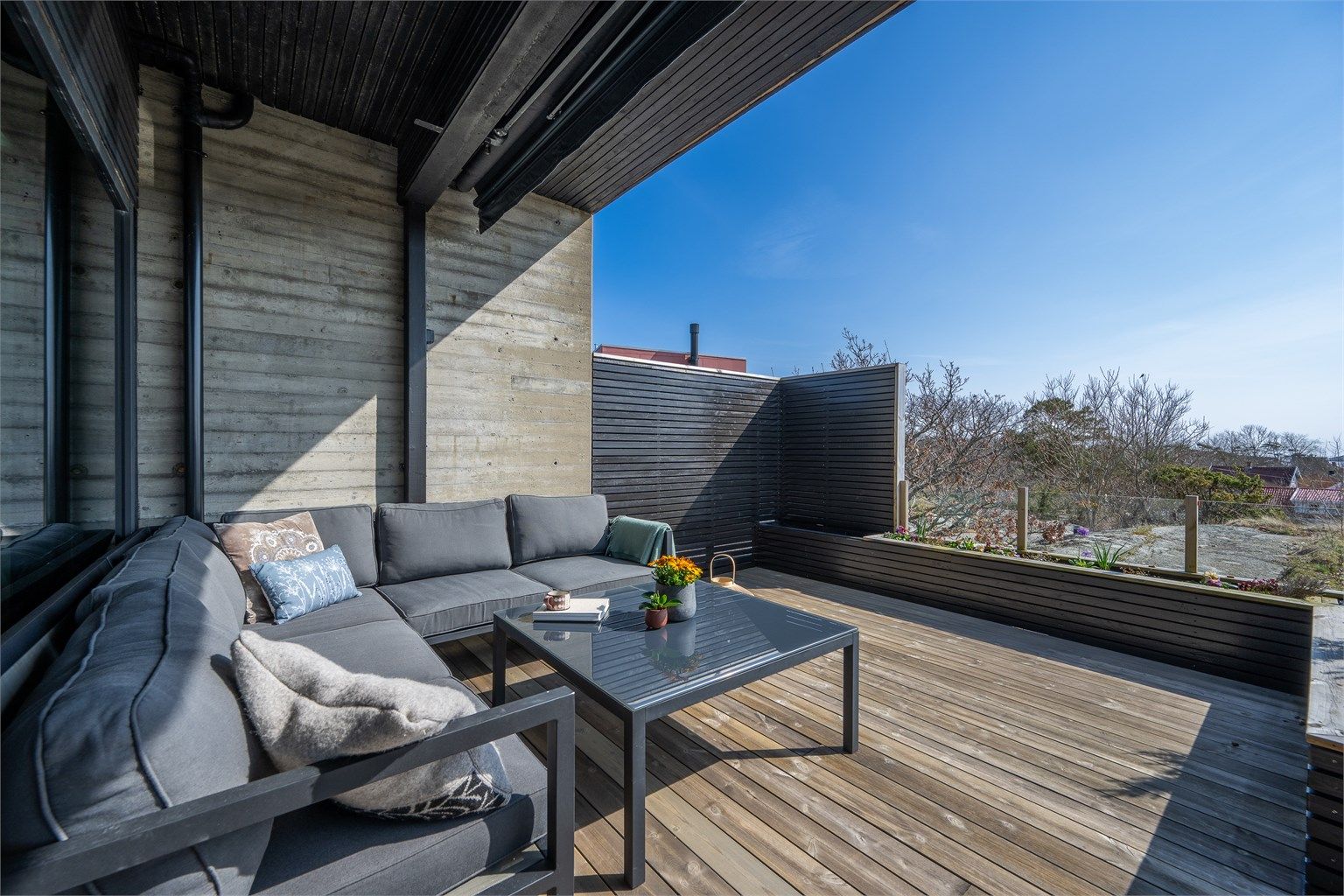 En lun og usjenert krok på terrassen, delvis under tak.