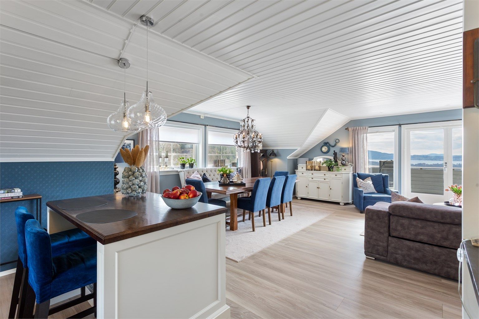 Kjøkkenøya fungerer som en naturlig romdeler og en hyggelig frokostplass.