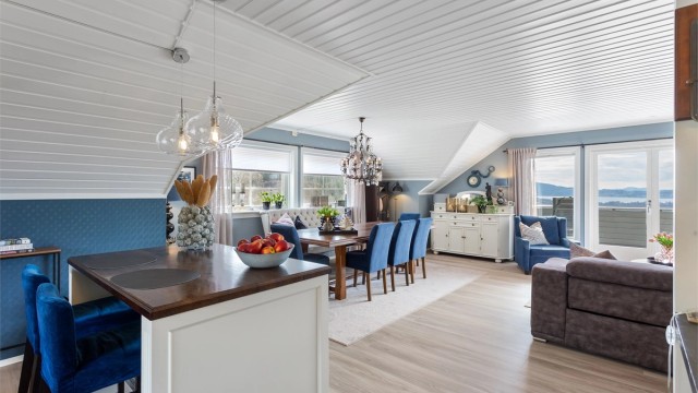 Kjøkkenøya fungerer som en naturlig romdeler og en hyggelig frokostplass.