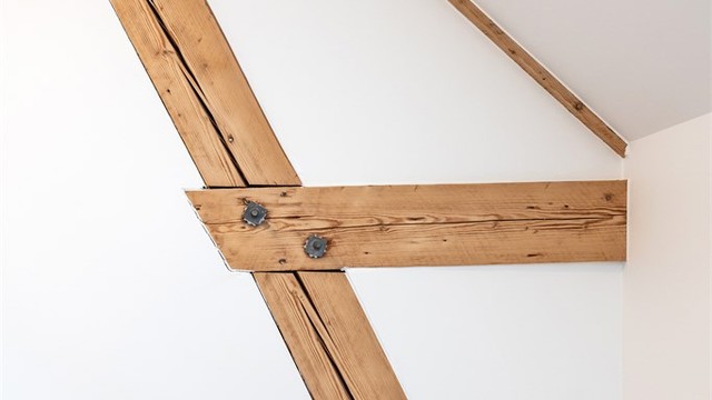 De originale trebjelkene er bevart og gir leiligheten en unik historisk forankring