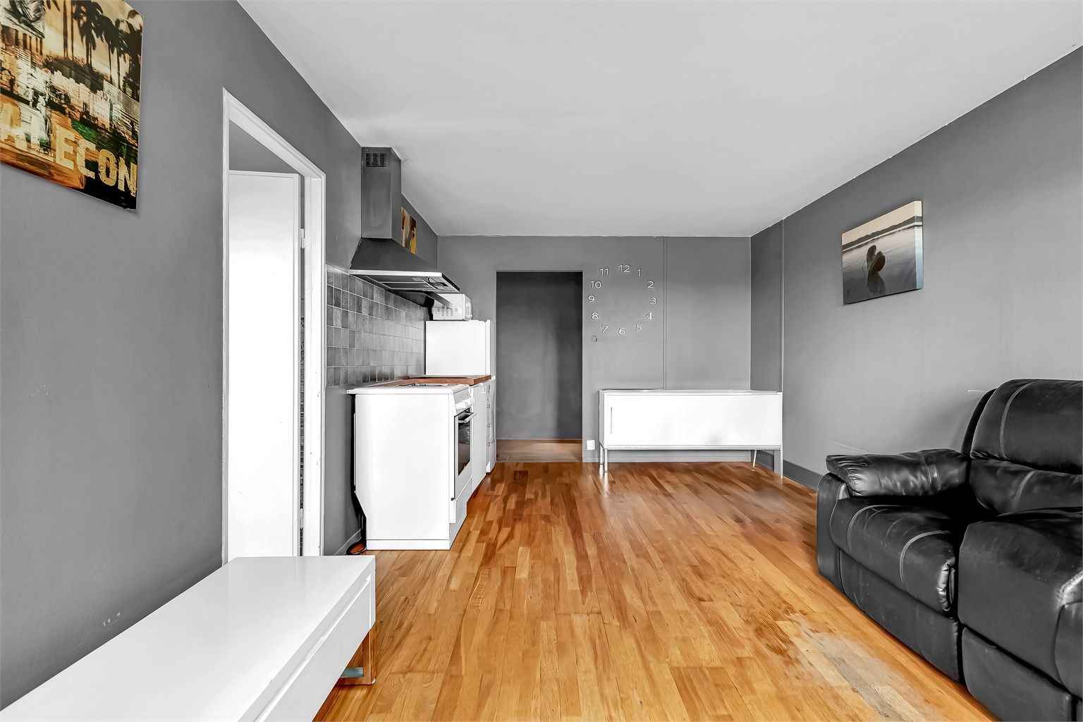 Kjøkken med åpen løsning mot stue. Innredning fra eldre ukjent årstall med glatte fronter. 