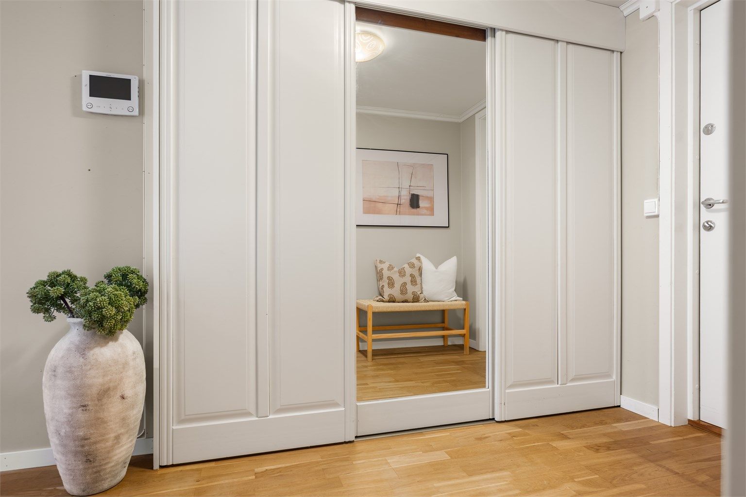 Skyvedørsgarderobe i gangen gir praktisk og plassbesparende oppbevaring.