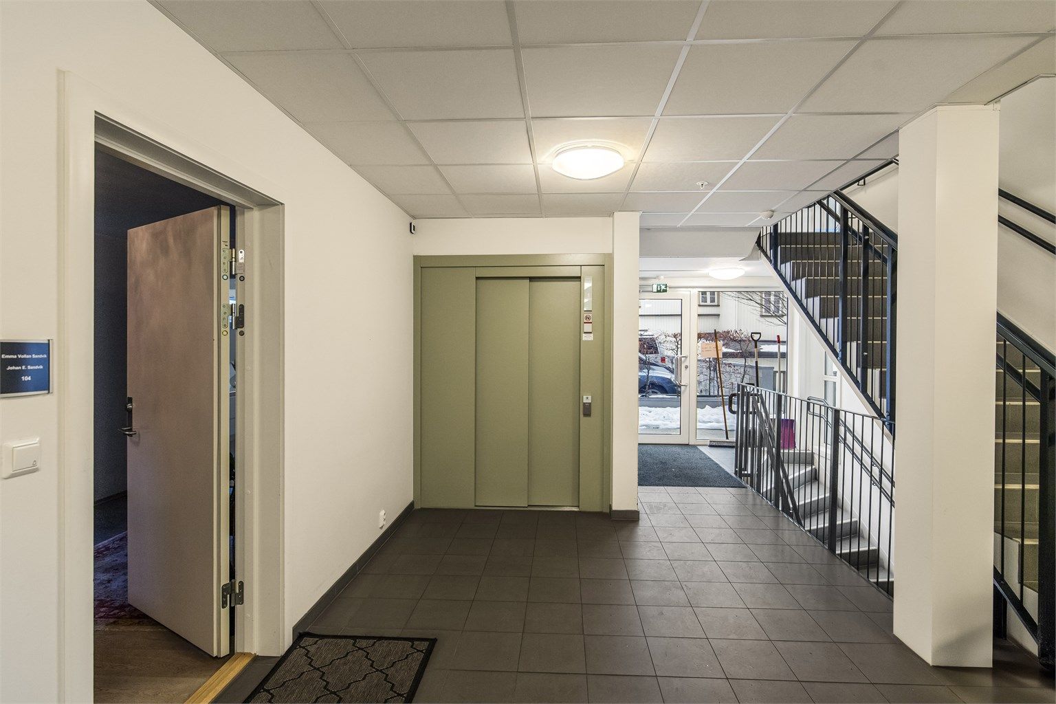 Hovedinngangen med heis til parkeringskjeller. Det er montert dørtelefon i leiligheten for å åpne til besøkende