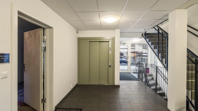 Hovedinngangen med heis til parkeringskjeller. Det er montert dørtelefon i leiligheten for å åpne til besøkende