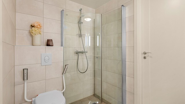 Badet er funksjonelt innredet med vegghengt toalett, dusjhjørne og gulvvarme.