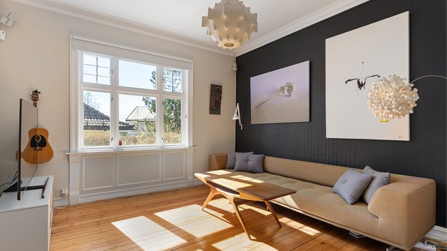 Stue med luftig takhøyde på ca. 3 meter og god plass til sofa og tv møblement