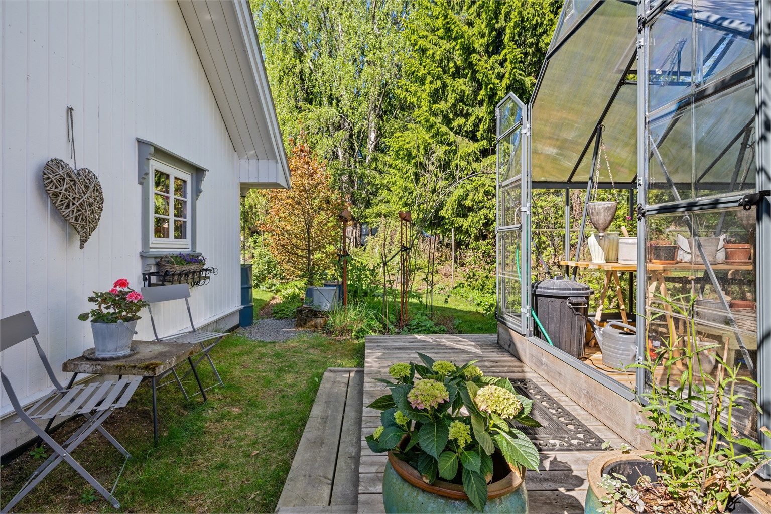 Fantastisk koselig beplantet hage med stauder og busker og et drivhus på ca. 8,8 kvm 