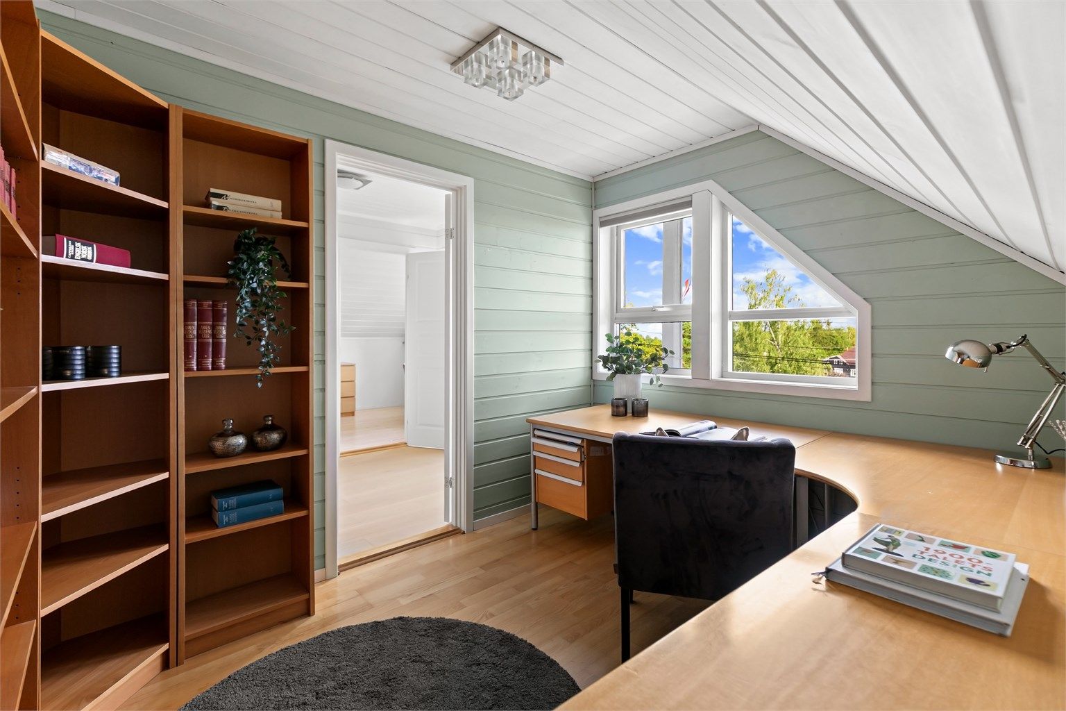 Romslig kontor med plass til stor arbeidspult og oppbevaring.