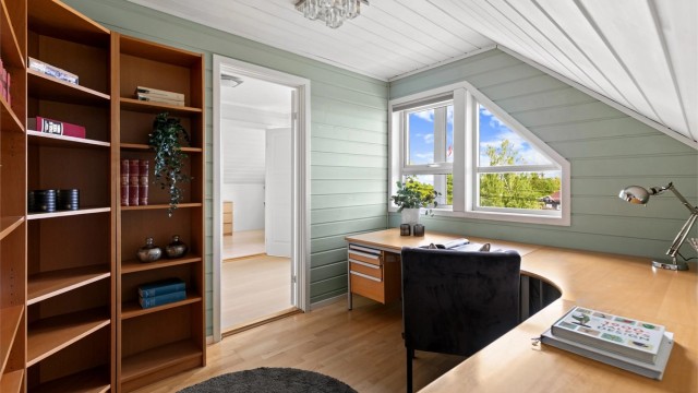 Romslig kontor med plass til stor arbeidspult og oppbevaring.