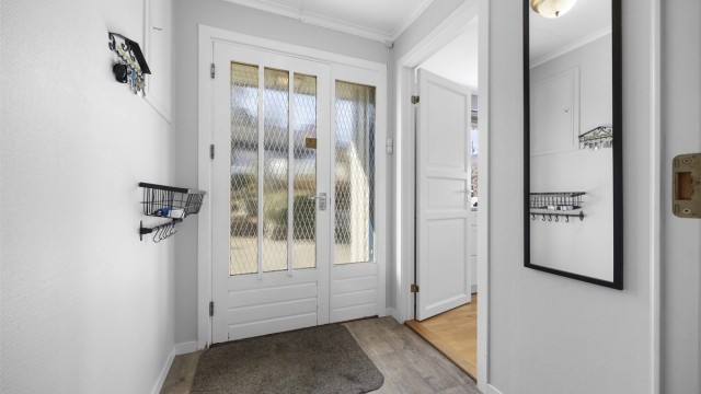 Vindfanget ønsker velkommen inn i boligens hovedetasje. Innerdøren med glassfelt gir et fint lysinnslipp til gangen.