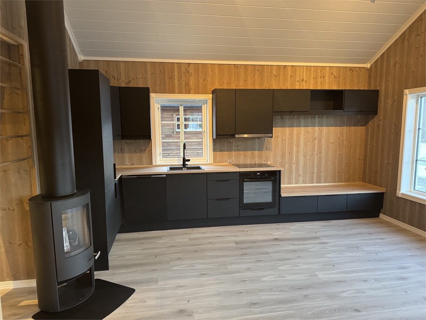 Innholdsrikt kjøkken med sittebenk - perfekt løsning til spisebord. 