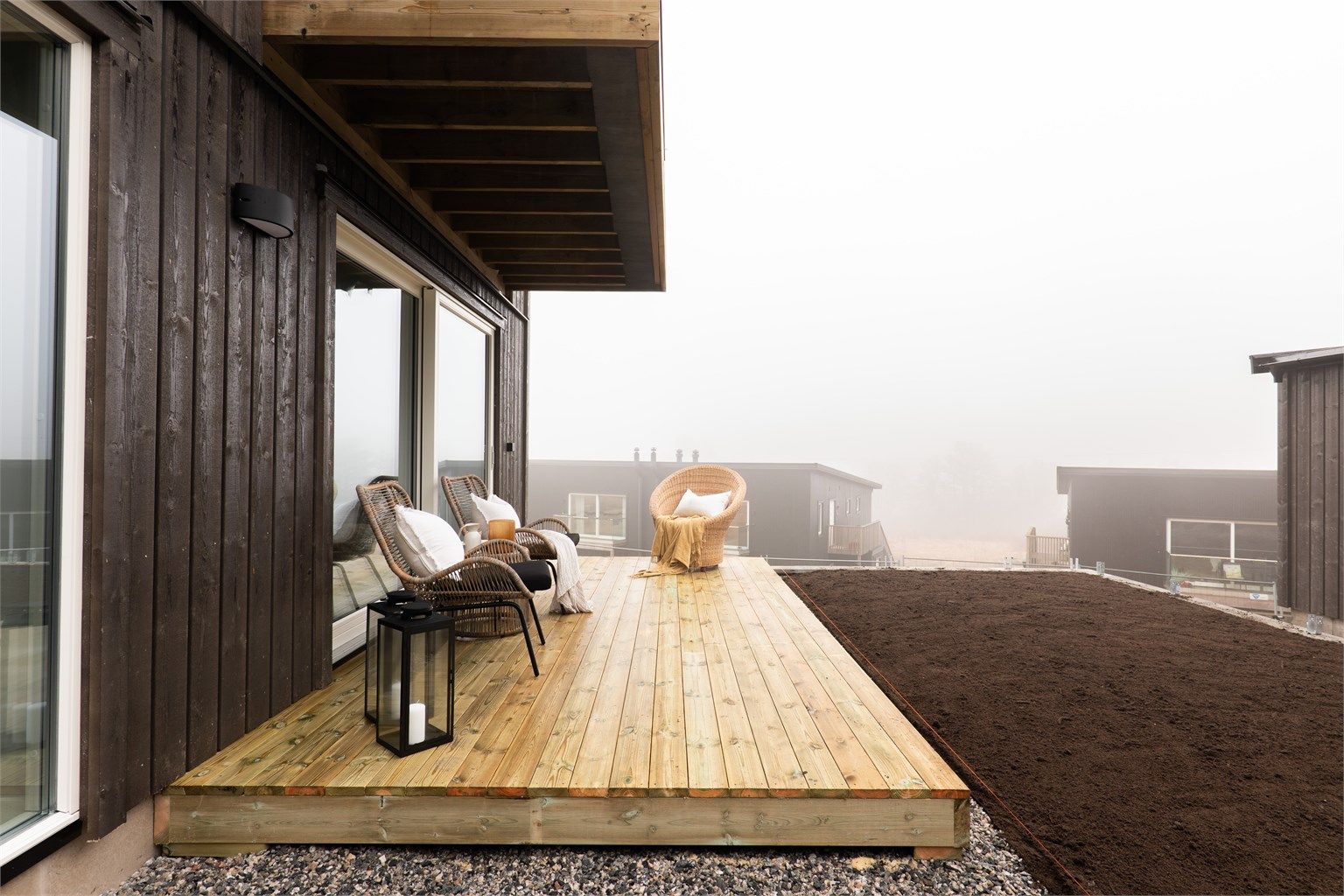 Skrånende terreng gjør det åpent og luftig mellom boligen. På terrassen er det både utsyn og gode solforhold.