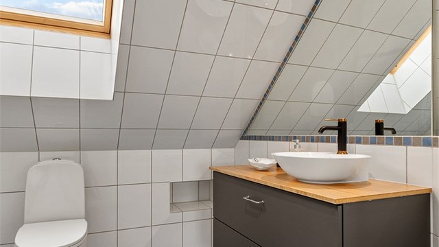 Badet i 2.etg er innredet med toppmontert vaskebolle, gulvvarme og takvindu som gir dagslys.