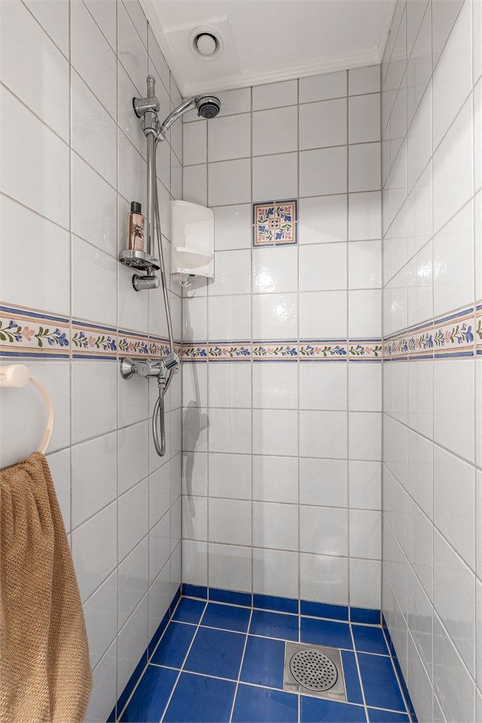 Ovenpåliggende servant med armatur. Speilskap med overlys og stikkontakt over servant. Dusj på gulv. Gulvstående toalett.