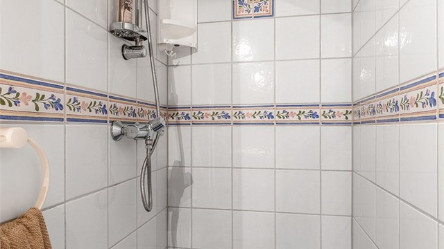 Ovenpåliggende servant med armatur. Speilskap med overlys og stikkontakt over servant. Dusj på gulv. Gulvstående toalett.