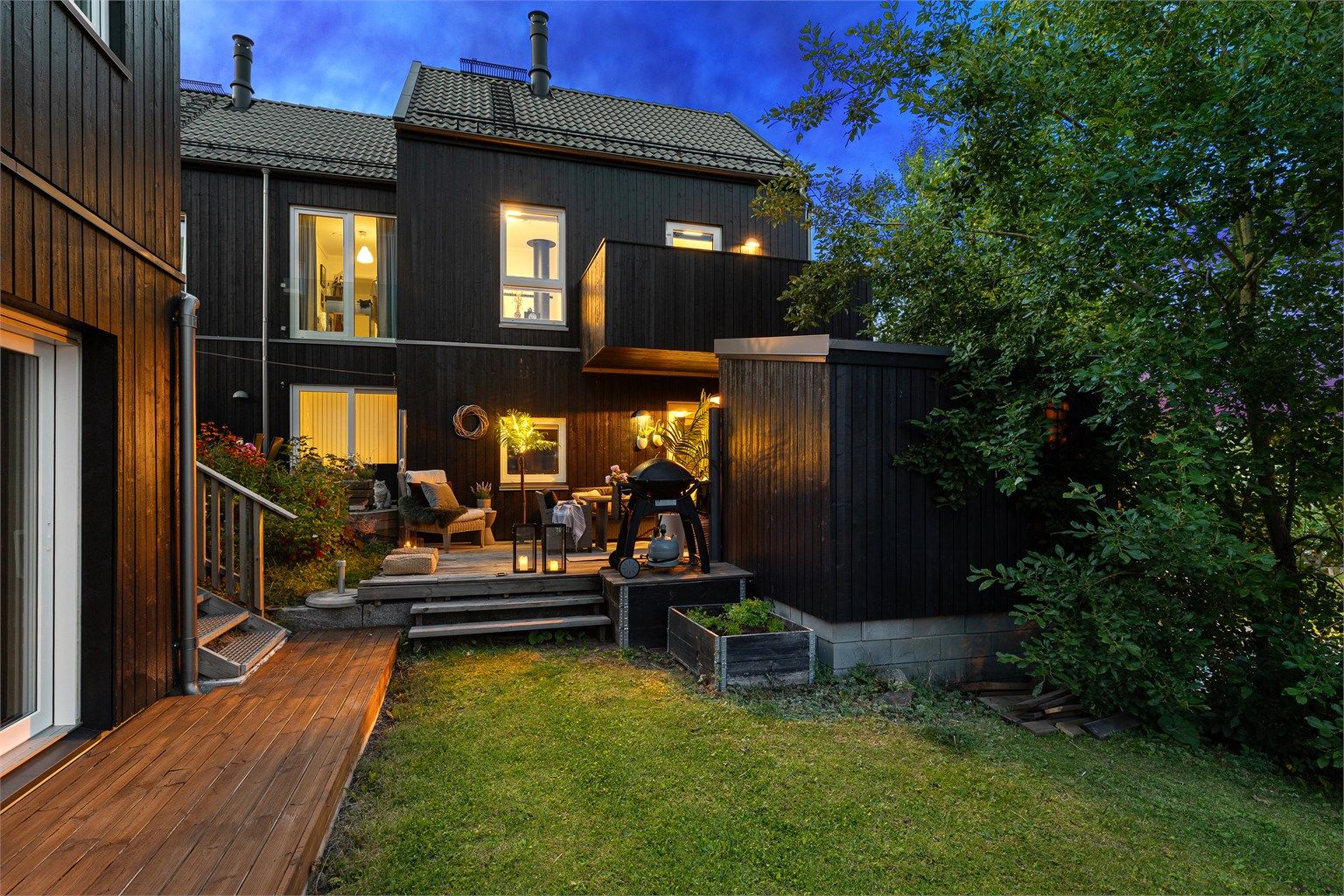 Terrassen grenser til grøntområde som forlenger følelsen av hage.