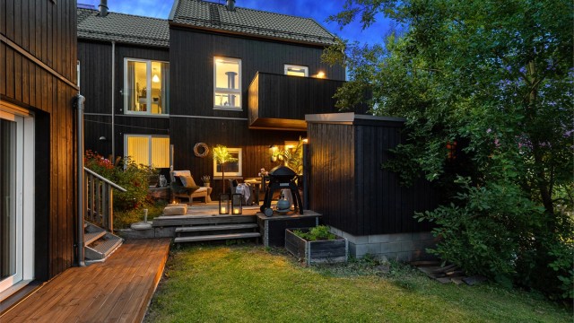 Terrassen grenser til grøntområde som forlenger følelsen av hage.