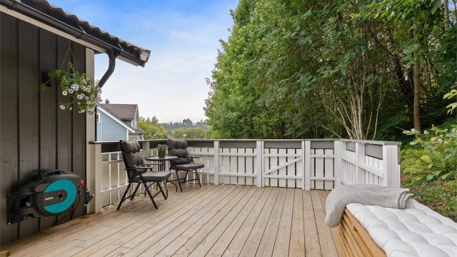 Skjermet terrasse på baksiden av boligen med god plass til utemøbler.