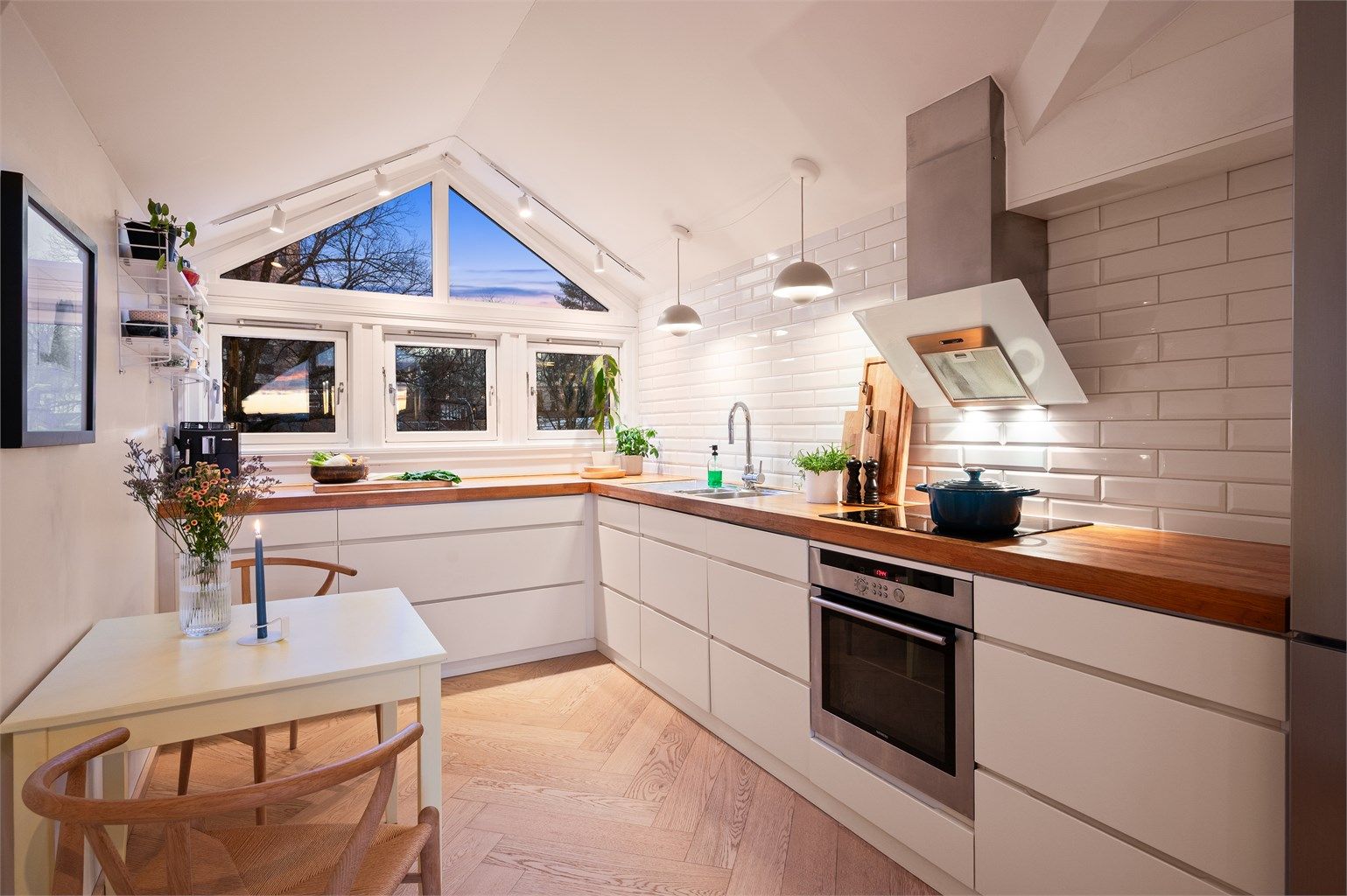 Et lyst og funksjonelt kjøkken med god arbeidsflyt og plass til en liten spiseplass.