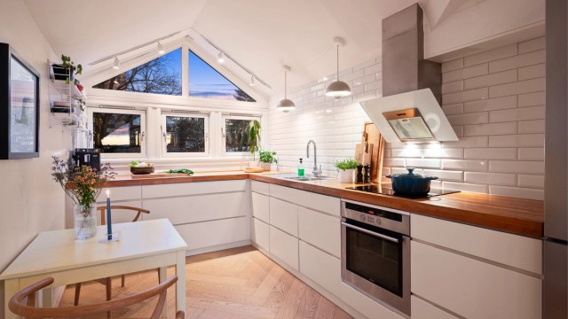 Et lyst og funksjonelt kjøkken med god arbeidsflyt og plass til en liten spiseplass.