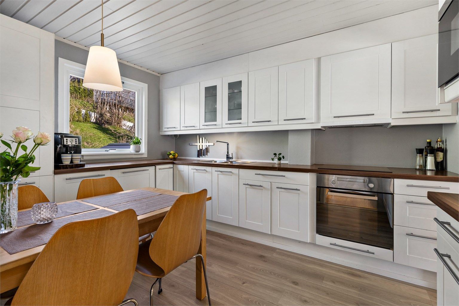 Ventilator i overskap. Gulvflater belagt med laminat. Malte veggflater. Panelbord i himling.