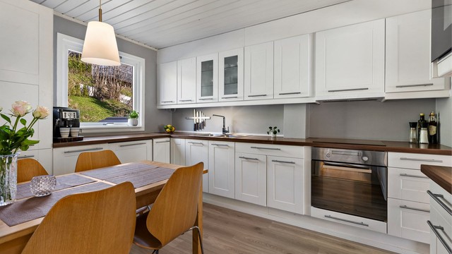 Ventilator i overskap. Gulvflater belagt med laminat. Malte veggflater. Panelbord i himling.