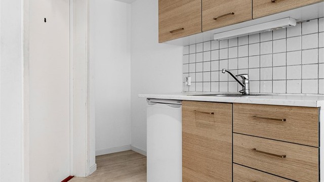Pen kjøkkeninnredning med over- og underskap i glatt utførelse.