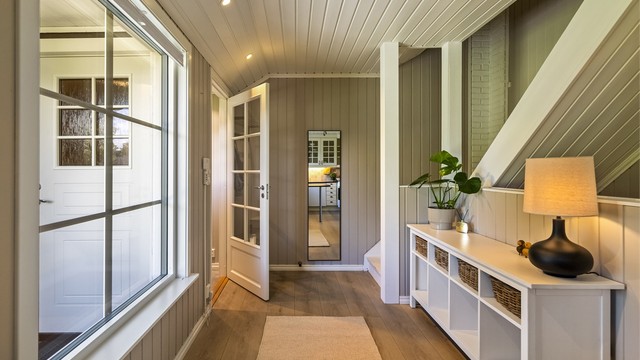 Gangen har innfelte downlights og leder videre inn til kjøkken og stue.